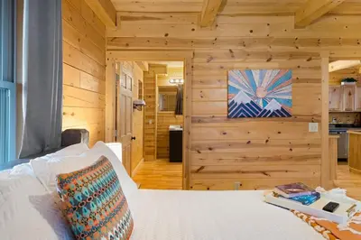a bedroom with a white bed in a wooden room at The Lookout in Logan