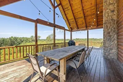 a wooden table and chairs on the deck of a cabin at The Lookout in Logan