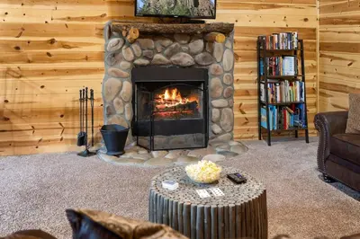 a living room with a fireplace in a log cabin at The Lookout in Logan