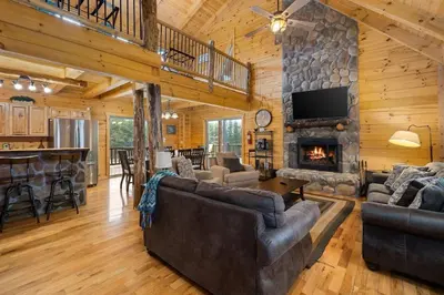 a living room with couches and a stone fireplace at The Lookout in Logan
