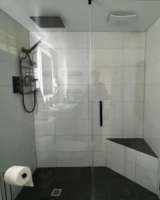 a bathroom with a glass shower with a toilet paper roll at Trendy in Tremont, CLE (Lower) in Cleveland