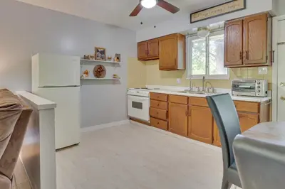a kitchen with wooden cabinets and a white refrigerator at Cozy Youngstown Apartment with Central AandC and Heating in Youngstown