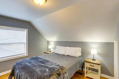 a bedroom with a bed with two night stands and a window at Dog-Friendly Port Clinton Home Walk to Lake Erie! in Port Clinton