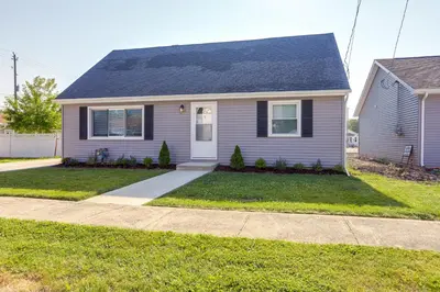 a gray house with a driveway in a yard at Dog-Friendly Port Clinton Home Walk to Lake Erie! in Port Clinton