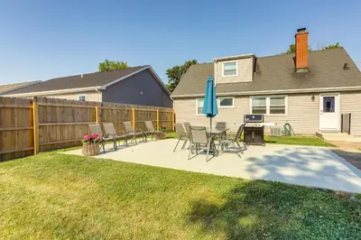 a patio with chairs and a table and a blue umbrella at Dog-Friendly Port Clinton Home Walk to Lake Erie! in Port Clinton