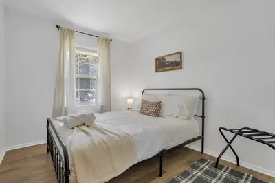 a white bedroom with a bed and a window at Housepitality - Electric Ave - 3 BDR and Hot Tub in Westerville
