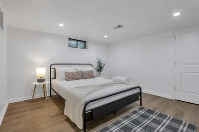 a white bedroom with a bed and a rug at Housepitality - Electric Ave - 3 BDR and Hot Tub in Westerville