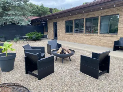 a patio with chairs and a fire pit and a building at The Hemlock Inn in Loudonville
