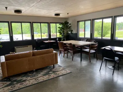a living room with a couch and a table and chairs at The Hemlock Inn in Loudonville