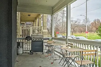 a porch with a grill and tables and chairs at Jungle House Columbus Downtown Free Parking Sleeps 6 - Steps to Convention Center & Nationwide Arena - 1BR Short North Luxury Home - Over 5,800 Five Star Stays in Columbus