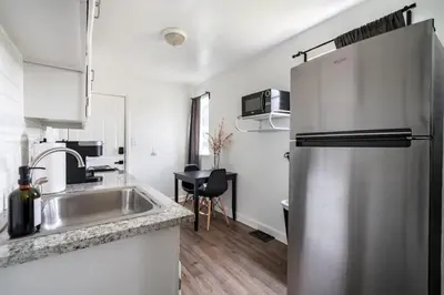 a kitchen with a stainless steel refrigerator and a sink at Jungle House Columbus Downtown Free Parking Sleeps 6 - Steps to Convention Center & Nationwide Arena - 1BR Short North Luxury Home - Over 5,800 Five Star Stays in Columbus