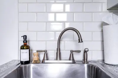 a kitchen sink with a bottle of wine next to it at Jungle House Columbus Downtown Free Parking Sleeps 6 - Steps to Convention Center & Nationwide Arena - 1BR Short North Luxury Home - Over 5,800 Five Star Stays in Columbus