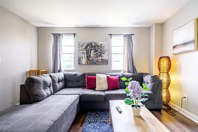 a living room with a gray couch and a table at Jungle House Columbus Downtown Free Parking Sleeps 6 - Steps to Convention Center & Nationwide Arena - 1BR Short North Luxury Home - Over 5,800 Five Star Stays in Columbus