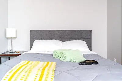 a bed with two towels and a hat on it at Jungle House Luxury Stays - Columbus Downtown Short North in Columbus
