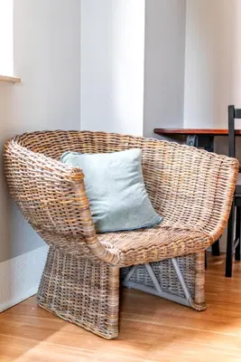 a wicker chair with a blue pillow in a room at Jungle House Luxury Stays - Columbus Downtown Short North in Columbus