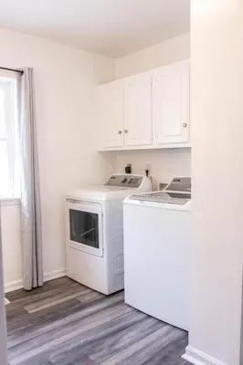 a kitchen with white cabinets and a washer and dryer at Hunter's Cove in Morehead