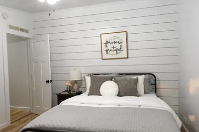 a bedroom with a bed with gray and white stripes at Maple Retreat with Big Pool in Dundee