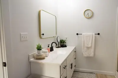 a white bathroom with a sink and a mirror at Maple Retreat with Big Pool in Dundee