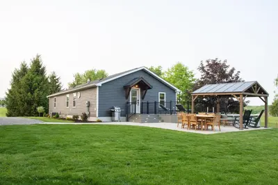 a house with a gazebo and a table on a lawn at Maple Retreat with Big Pool in Dundee