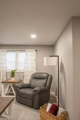 a living room with a chair and a table at Haven on 41 in Warsaw