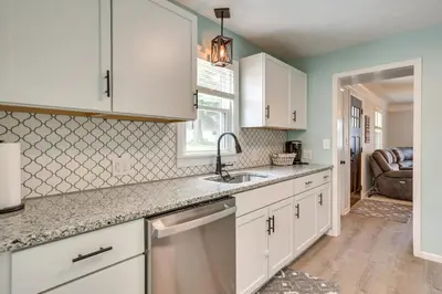 a kitchen with white cabinets and a sink at Chippewa Lake Cottage with Fire Pit! in Chippewa Lake