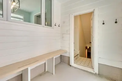 a room with a bench and a mirror at Chippewa Lake Cottage with Fire Pit! in Chippewa Lake