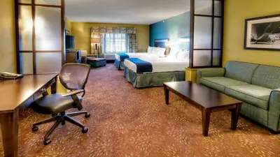 a hotel room with a bed and a couch and a chair at Holiday Inn Express & Suites Pittsburgh SW/Southpointe by IHG in Canonsburg