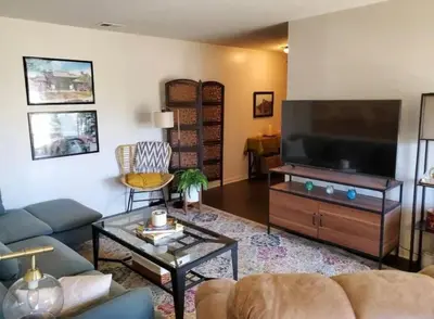 a living room with a large flat screen tv at The Redhawk Hideaway: Charming 2BR Condo near Miami Univ in Oxford! Book now! in Oxford