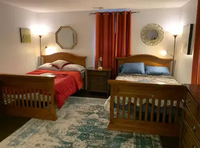 a bedroom with two beds and a mirror at The Redhawk Hideaway: Charming 2BR Condo near Miami Univ in Oxford! Book now! in Oxford