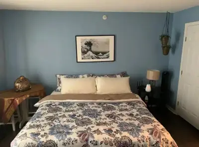 a bedroom with a bed with a blue wall at The Redhawk Hideaway: Charming 2BR Condo near Miami Univ in Oxford! Book now! in Oxford