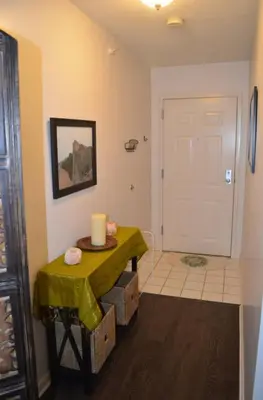 a room with a table with a candle and a door at The Redhawk Hideaway: Charming 2BR Condo near Miami Univ in Oxford! Book now! in Oxford
