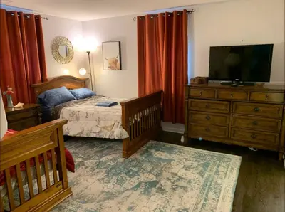 a bedroom with a bed and a flat screen tv at The Redhawk Hideaway: Charming 2BR Condo near Miami Univ in Oxford! Book now! in Oxford