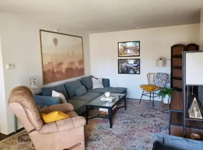 a living room with a couch and a table at The Redhawk Hideaway: Charming 2BR Condo near Miami Univ in Oxford! Book now! in Oxford