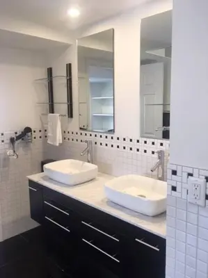 a bathroom with two sinks and two mirrors at Luxury three story apartment in SHORT NORTH in Columbus
