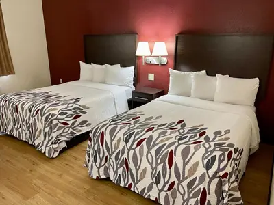 two beds sitting next to each other in a hotel room at Red Roof Inn Sandusky - Milan in Milan
