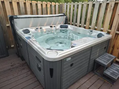 a jacuzzi tub on a deck with a fence at Hickory House B & B in Hickory
