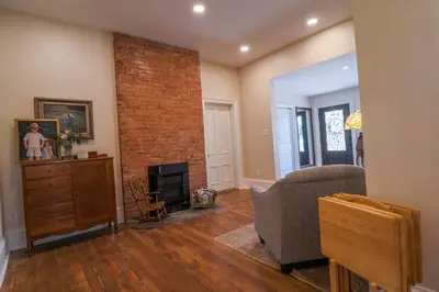 a living room with a couch and a brick wall at Hickory House B & B in Hickory