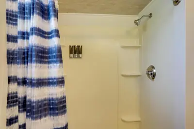 a shower with a blue and white curtain in a bathroom at Welcoming Port Clinton Vacation Rental! in Port Clinton