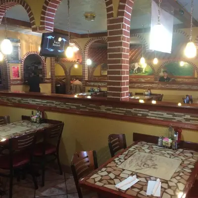 a dining room with two tables and a bar at Pacer Inn & Suites Motel in Delaware