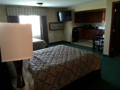 a hotel room with a bed and a kitchen at Pacer Inn & Suites Motel in Delaware