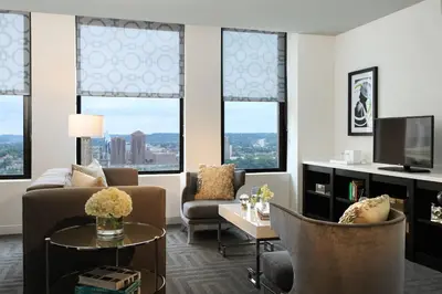 a living room with a couch and chairs and windows at Renaissance Cincinnati Downtown Hotel in Cincinnati