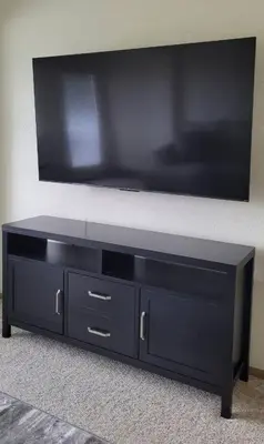a black entertainment center with a flat screen tv on a wall at Sunnie Days condo in Oak Harbor on Lake Erie! in Sand Beach