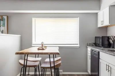 a kitchen with a table and two stools in front of a window at Westlake Apartment in Westlake