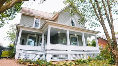 an old house with a white front porch at Downtown Escape Great for large families & groups in Sugarcreek