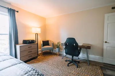 a bedroom with a bed and a desk and a chair at Downtown Escape Great for large families & groups in Sugarcreek