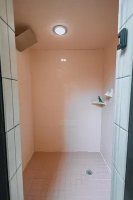 a bathroom with a shower with pink tile at Downtown Escape Great for large families & groups in Sugarcreek