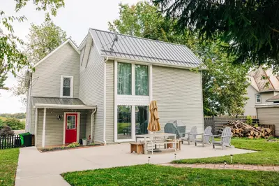 a house with a patio and a red door at Downtown Escape Great for large families & groups in Sugarcreek