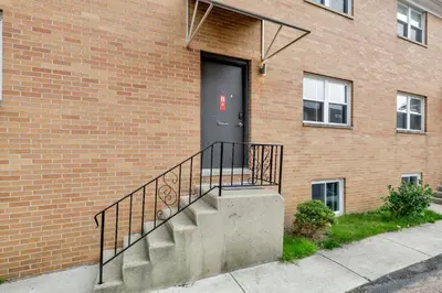 a brick building with a black door and stairs at The Worthington - 3 BR 2 5 Bath and Parking in Columbus