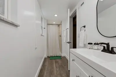 a white bathroom with a sink and a mirror at The Worthington - 3 BR 2 5 Bath and Parking in Columbus