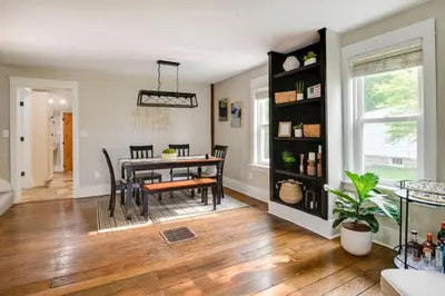 a dining room and living room with a table and chairs at Bell Street by the Falls in Chagrin Falls